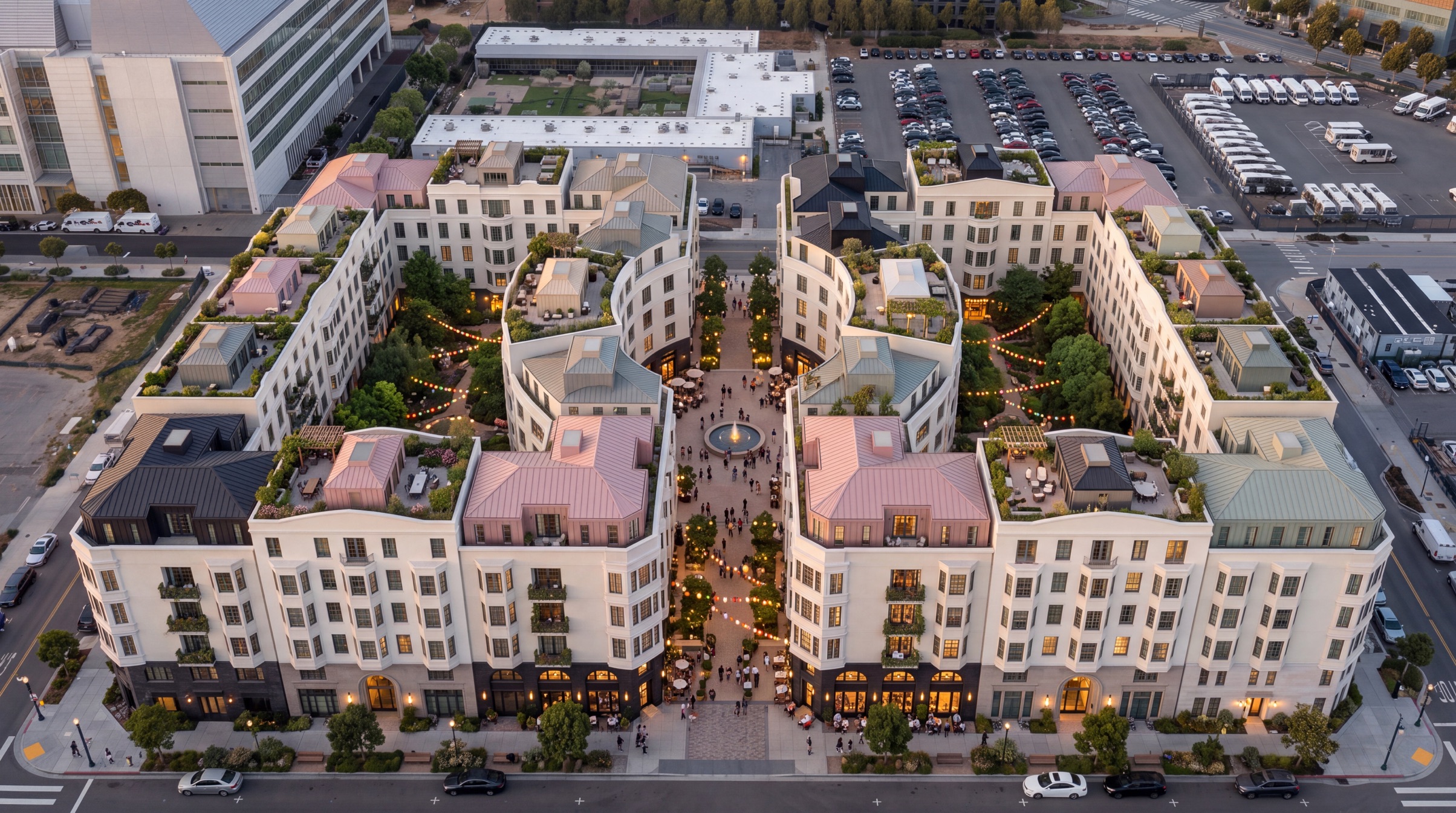 Photorealistic Mission Bay concept at dusk: the two courtyard blocks frame lush gardens and a lively fountain piazza, with illuminated shops and planted roof terraces.